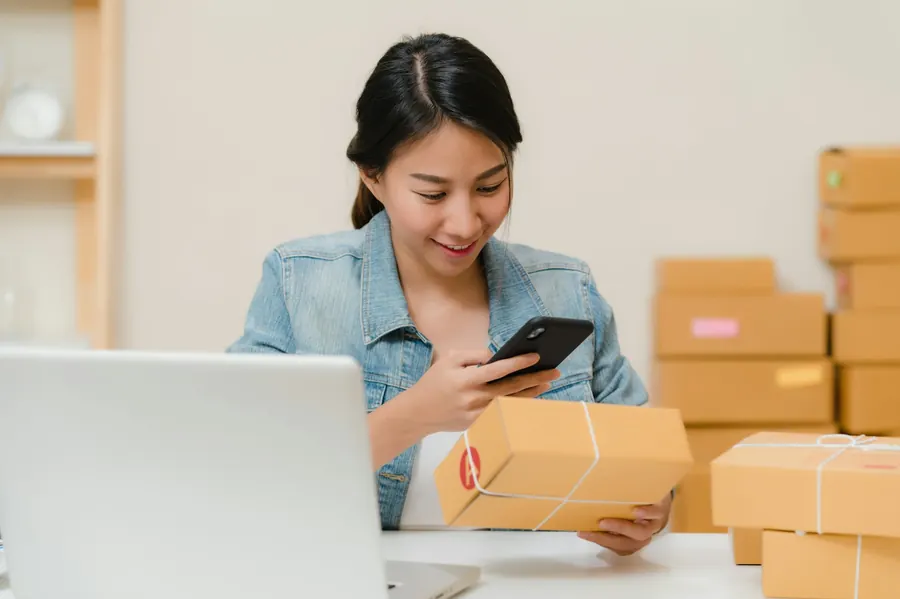 Telefonunda gelen mesajı okuyan işletme çalışanı